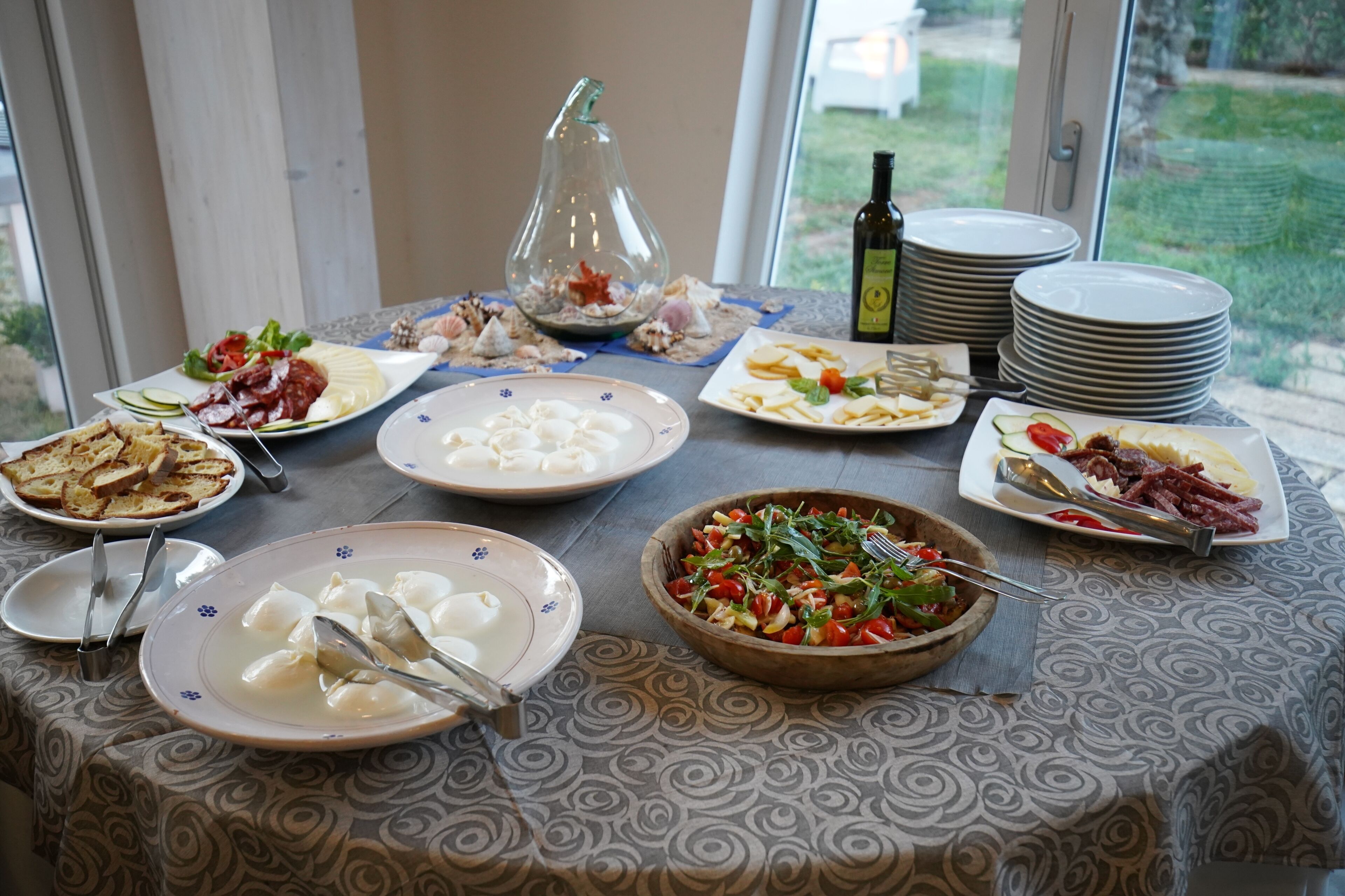 A dining table with various dishes, plates, and utensils.