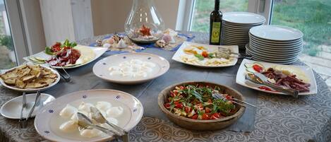 A dining table with various dishes, plates, and utensils.