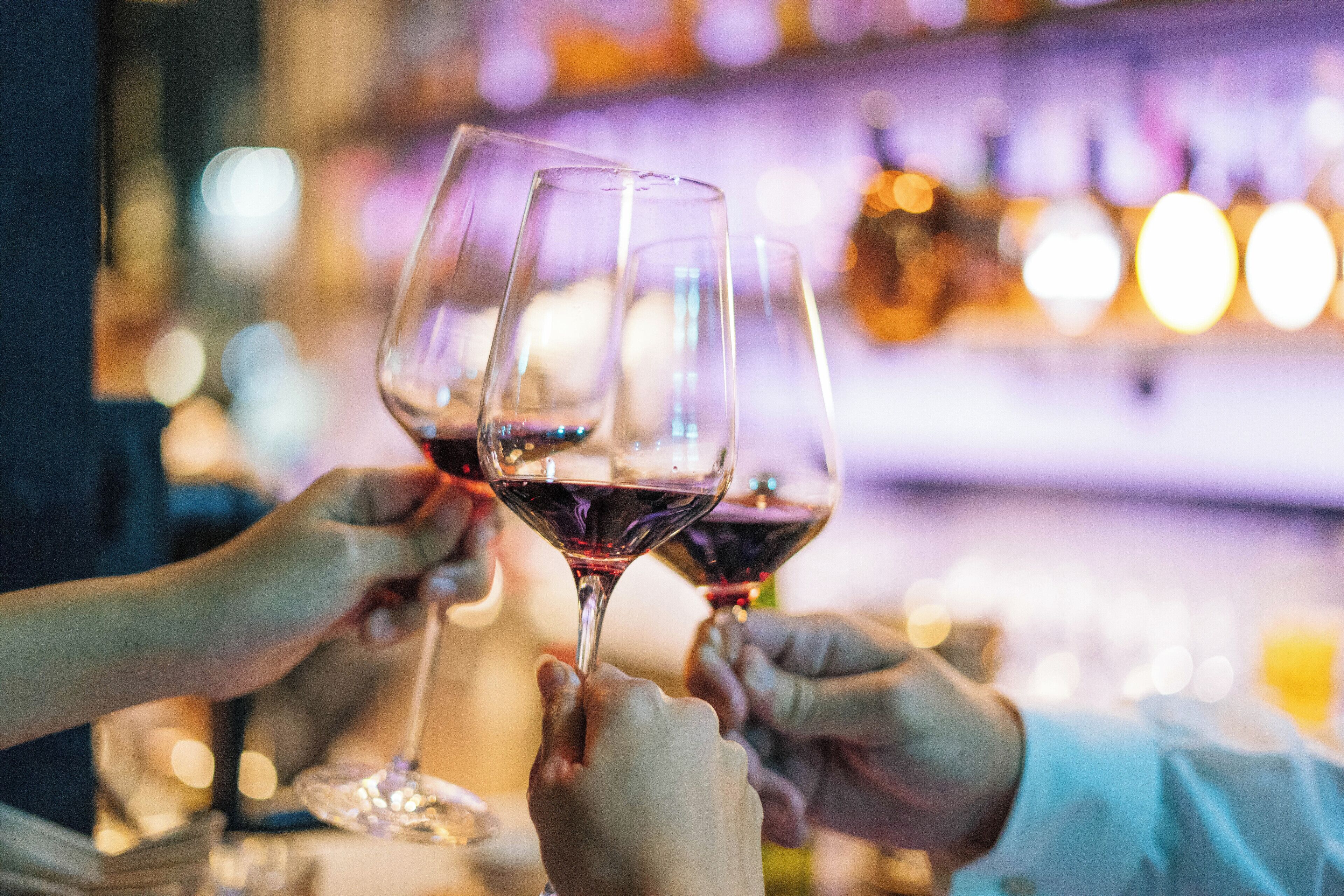 A bar setting with multiple glasses of red wine.