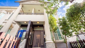 A building with a dark entrance door, white columns, and a balcony. - Ying Hsuan House (Hualien City)