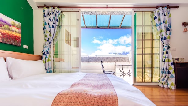 A hotel room with a bed, a view of the sky and a balcony. - Ying Hsuan House (Hualien City)