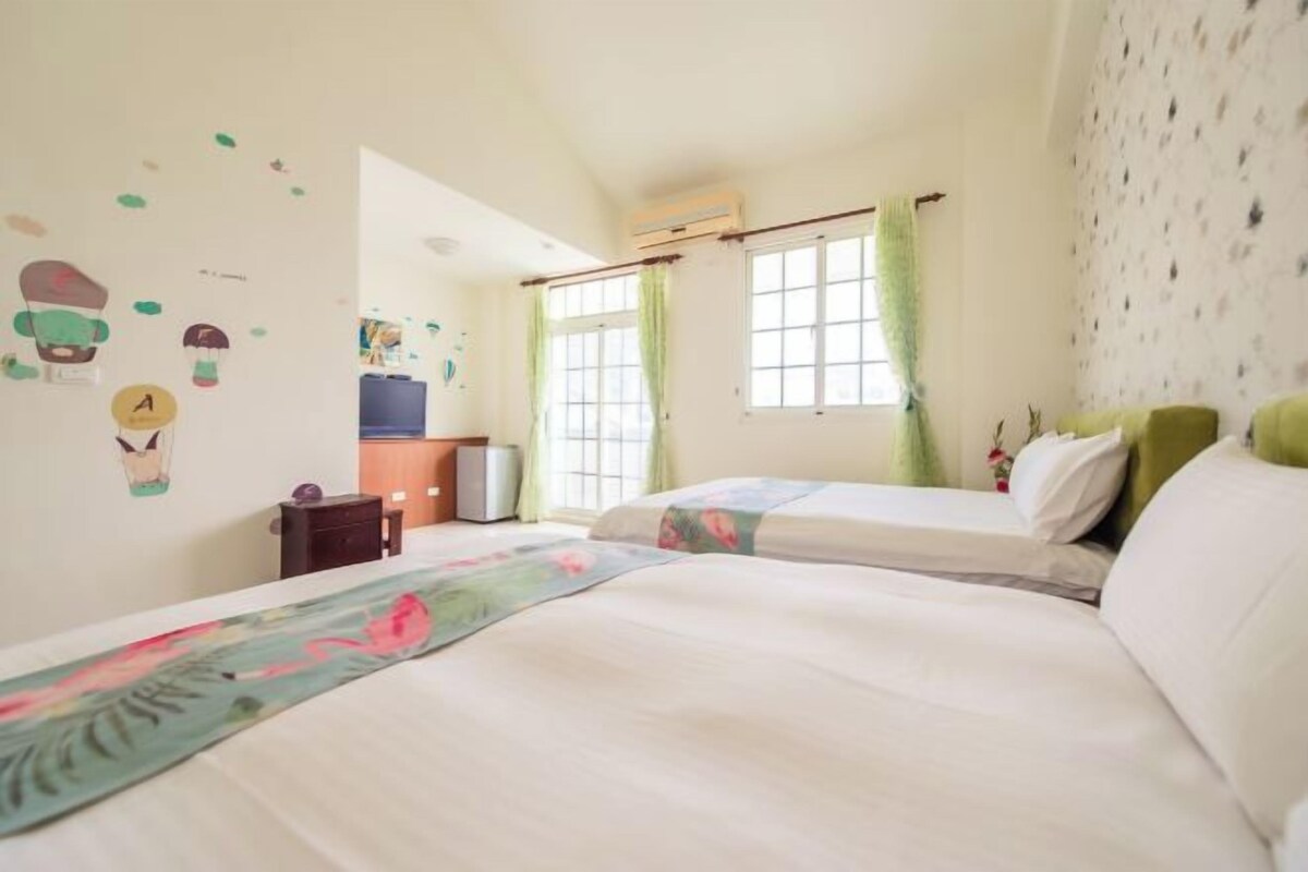 Un dormitorio con dos camas, un aparador, un escritorio y una ventana con cortinas.