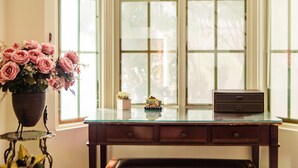 A desk with a vase of pink flowers, a small potted plant, and a toy car. - Ying Hsuan House (Hualien City)