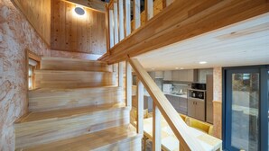 Un escalier en bois mène à une cuisine moderne dotée d’appareils électroménagers intégrés.