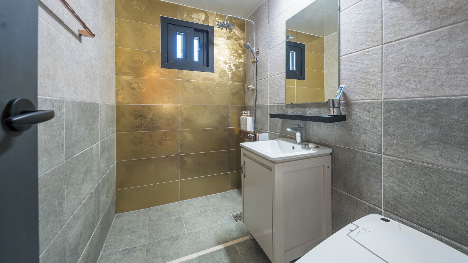 Ein Badezimmer mit Dusche, Waschbecken, Spiegel und Toilette.
