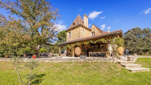 Una casa de piedra con un patio cubierto y zona de estar al aire libre.