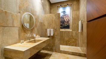 Un baño moderno con un lavamanos grande, un espejo y una zona de ducha.