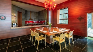Een moderne keuken met een centraal eiland, houten lambrisering en een kroonluchter.