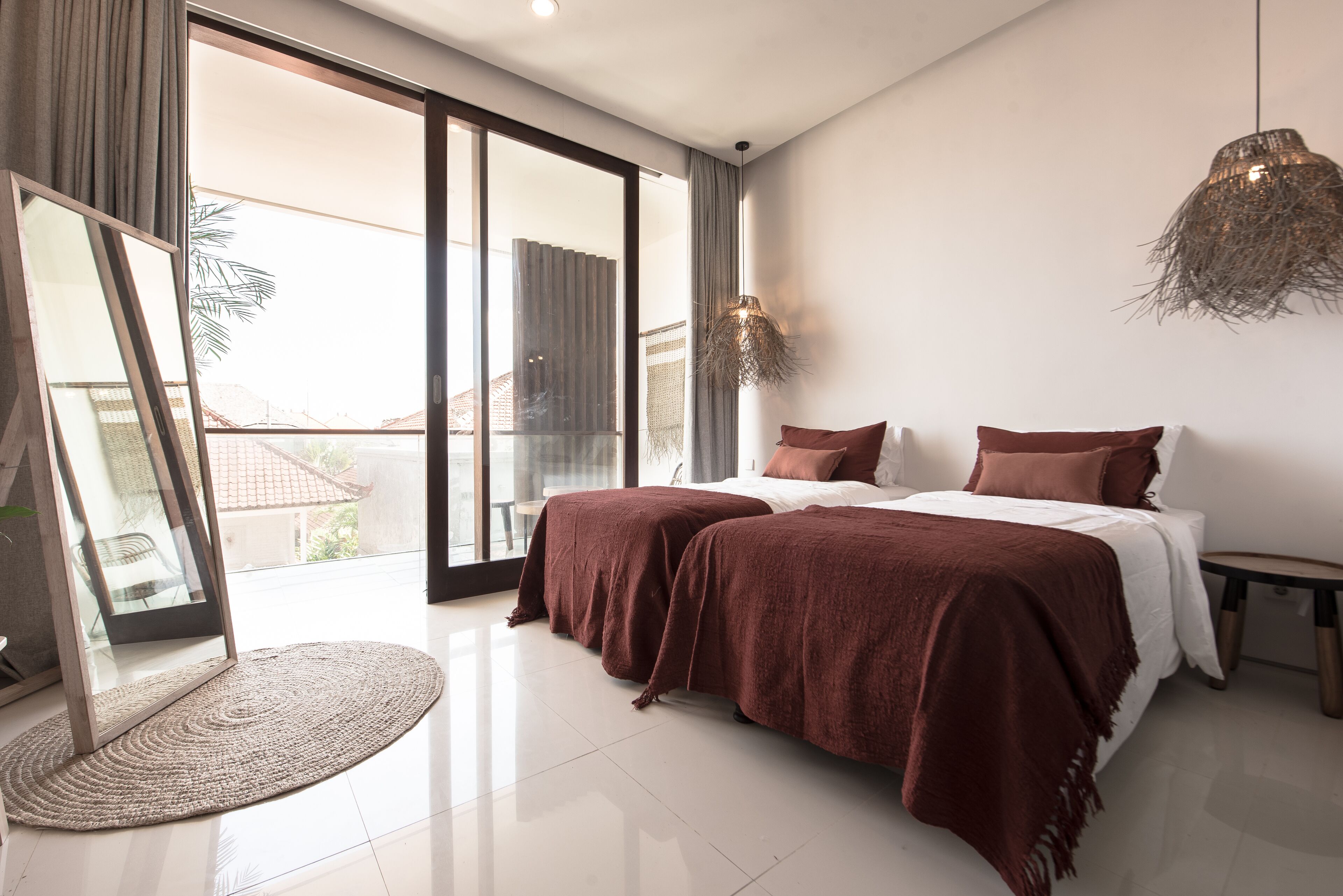 A modern bedroom with a large bed, a view to the outside, and a large window.