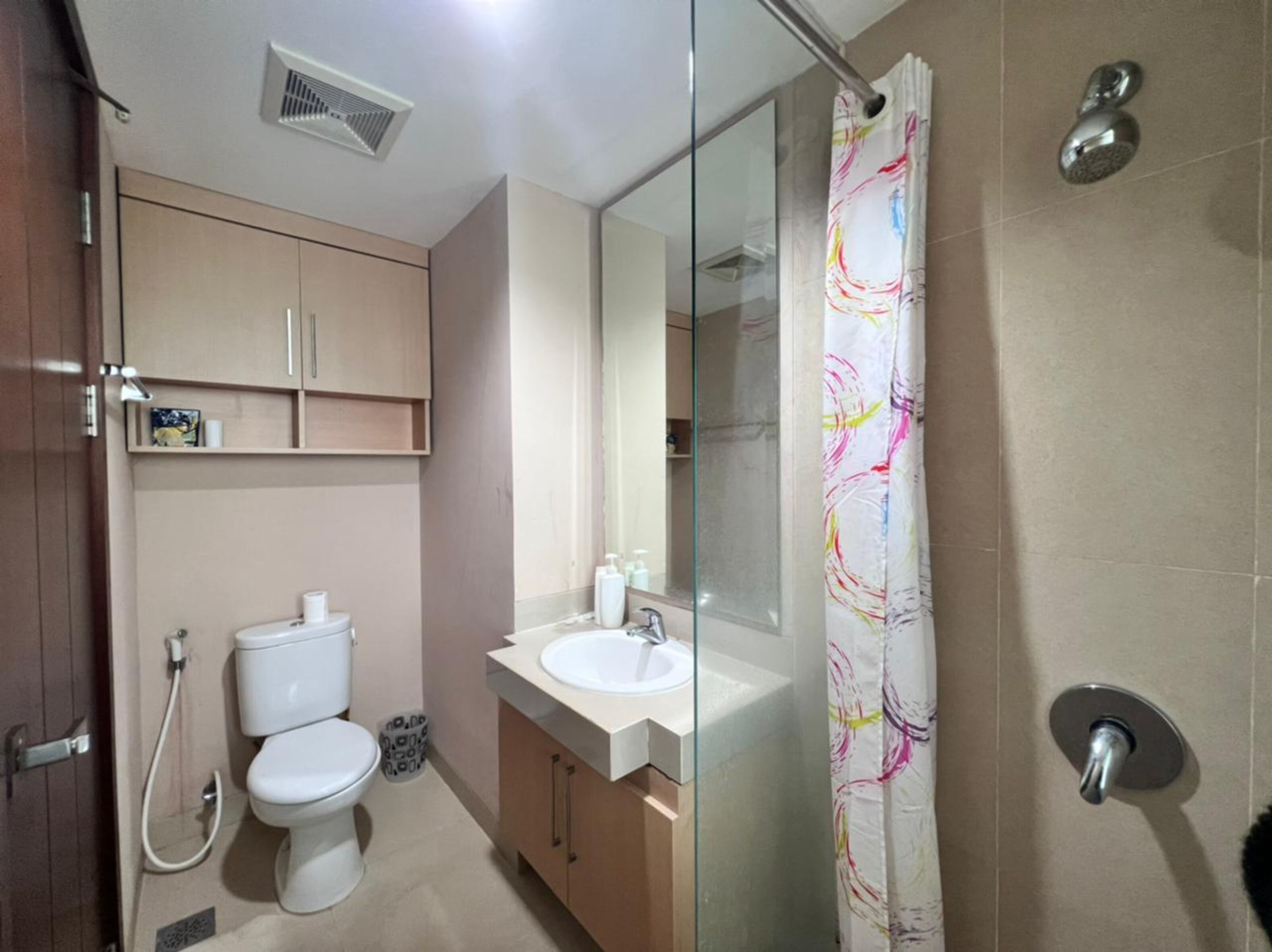 A modern bathroom with a toilet, sink, and shower.
