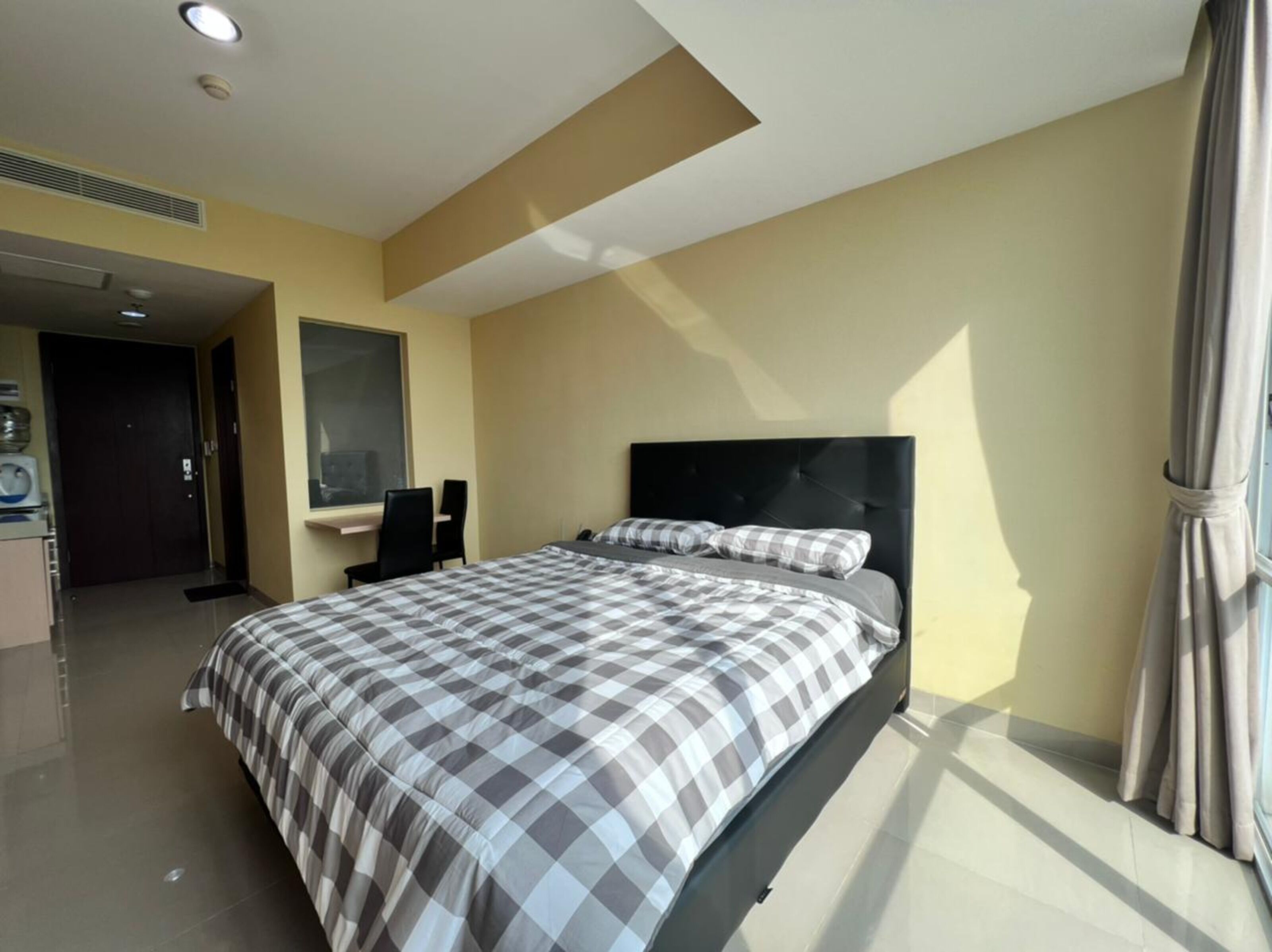 Une chambre d’hôtel moderne avec un grand lit, un bureau et une fenêtre.