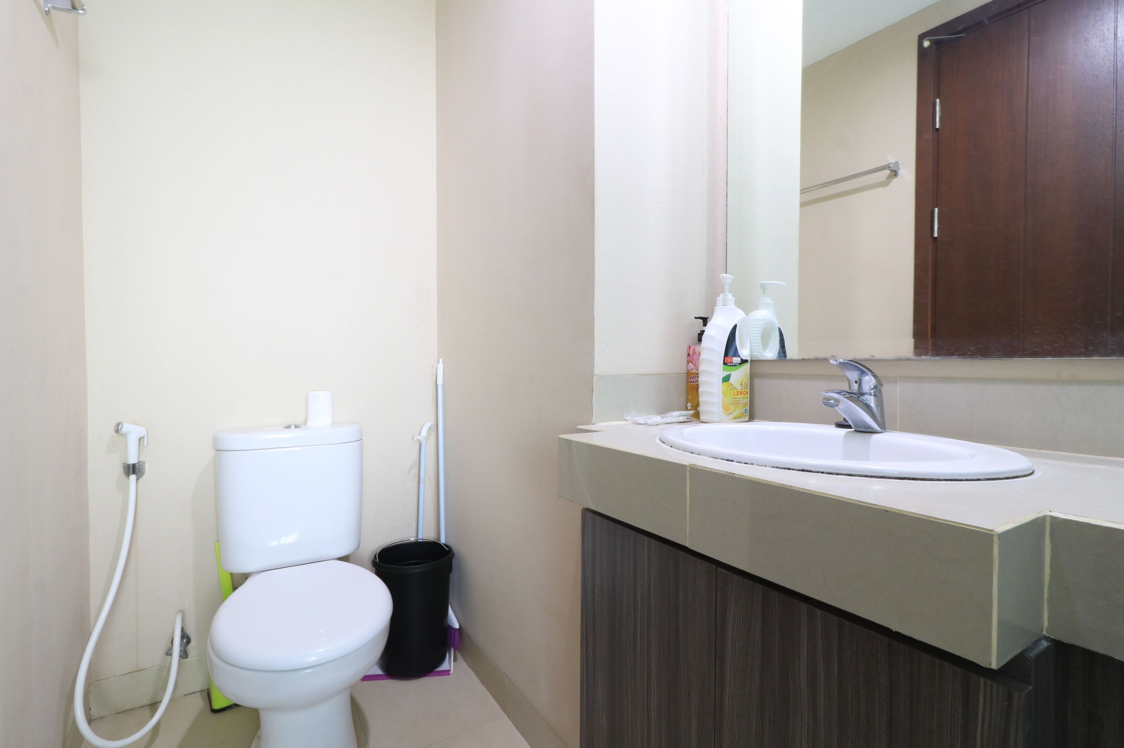A bathroom with a toilet, bidet, sink, and a mirror above the sink.
