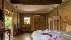 Una habitación de madera con una cama, un escritorio y una ventana.