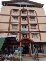 Un edificio de varios pisos con una entrada central, múltiples ventanas y un letrero.