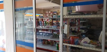 Un mostrador refrigerado con diversas bebidas envasaladas y aperitivos.