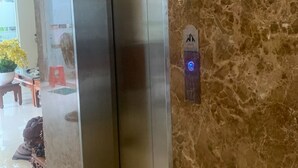 An elevator with a marble wall and a phone mounted on it. - Phu Si Hotel (Ho Chi Minh City)