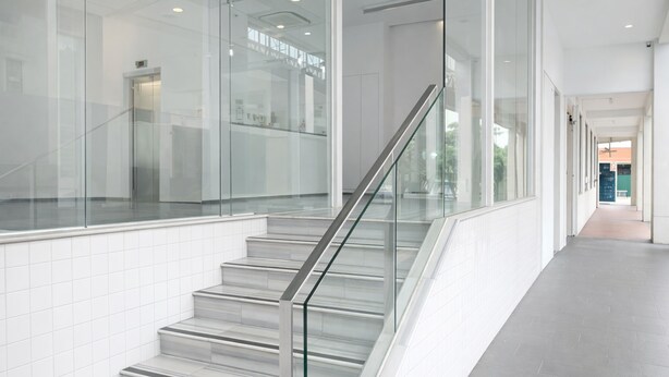 A modern interior with a glass railing staircase, white tiled walls, and a long hallway. - A Hotel Dickson, Stay From 9PM To 8AM (Singapore)
