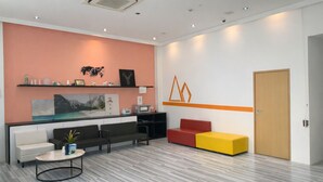A modern reception area with a marble floor, a reception desk, a red and yellow seating area, and a wall-mounted shelf with various items. - A Hotel Dickson, Stay From 9PM To 8AM (Singapore)
