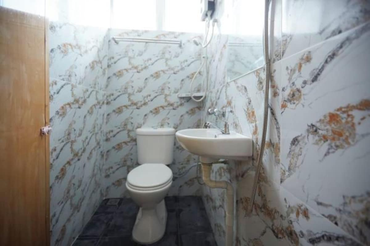 Une salle de bain avec des toilettes, un lavabo et une douche.