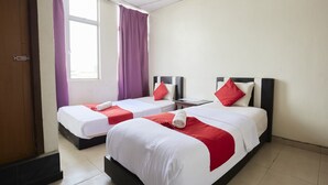 A hotel room with two beds, each with white bedding and red accents, a small table, and a window with purple curtains. - Jerteh Hotel, Terengganu (Jerteh)