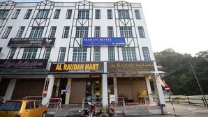 A hotel with multiple floors, a sign for Madani Hotel, and storefronts including Al Raudah Mart. - Madani Hotel Cameron Highland (Tanah Rata)