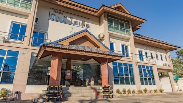 A building with a prominent entrance, large windows, and a sign above the entrance.