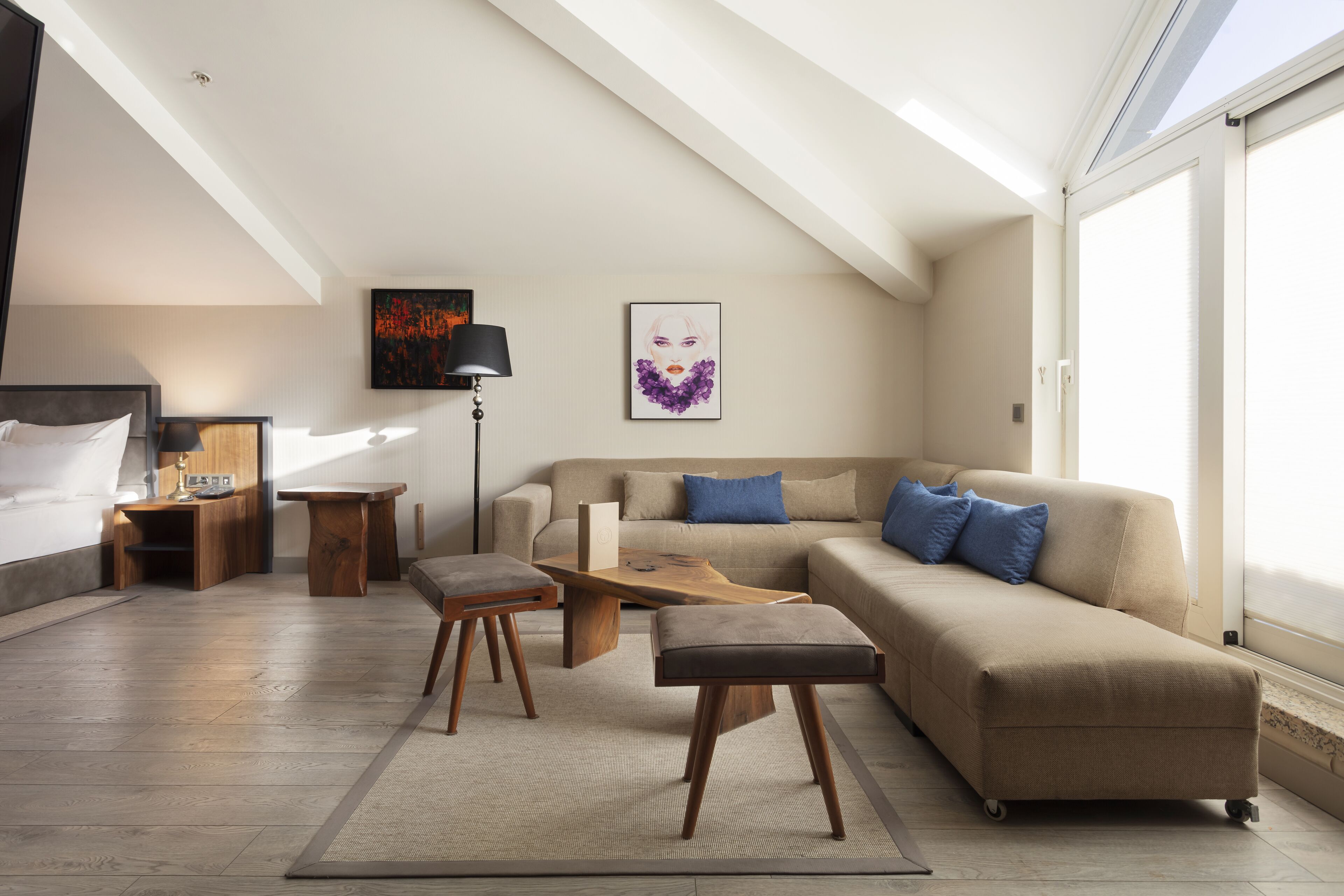 Una sala de estar moderna con sofá, mesa de centro, reposapiés, escritorio y cama.