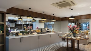 A modern kitchen with a central island, pendant lighting, and a patterned floor.