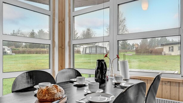 A dining area with a table set for two, a loaf of bread, and a coffee maker. - Cozy home in Roslev with WiFi (Roslev)
