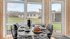 A dining area with a table set for two, a coffee maker, and a loaf of bread. - Cozy home in Roslev with WiFi (Roslev)