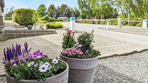 A paved entrance with flower planters and a gated driveway. - Cozy home in Roslev with WiFi (Roslev)