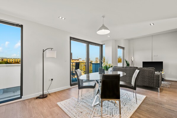 Enjoy the city view from the large window in this stylish living room with a dining area and flat-screen TV.