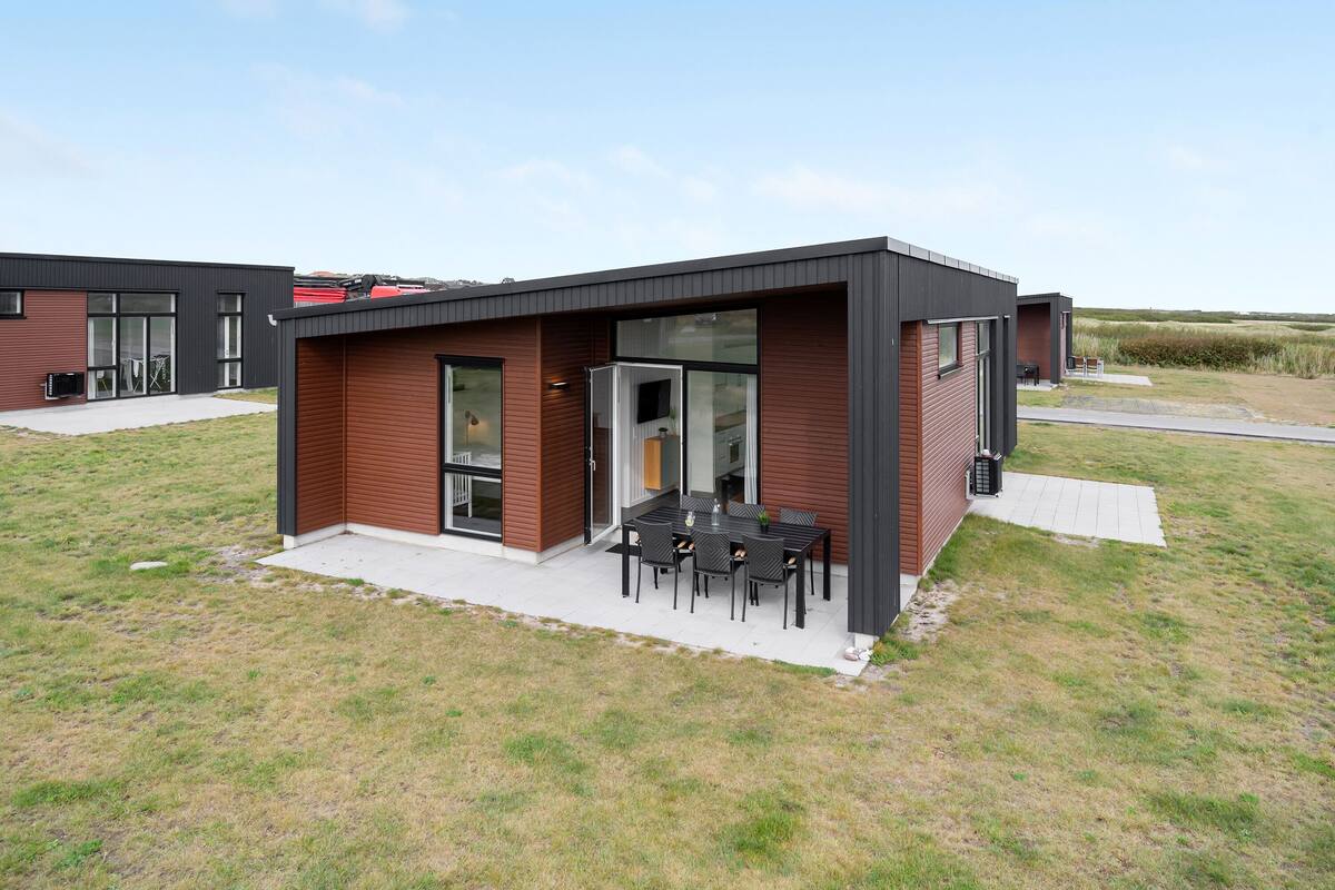 Un edificio moderno con un patio que incluye una mesa y sillas.