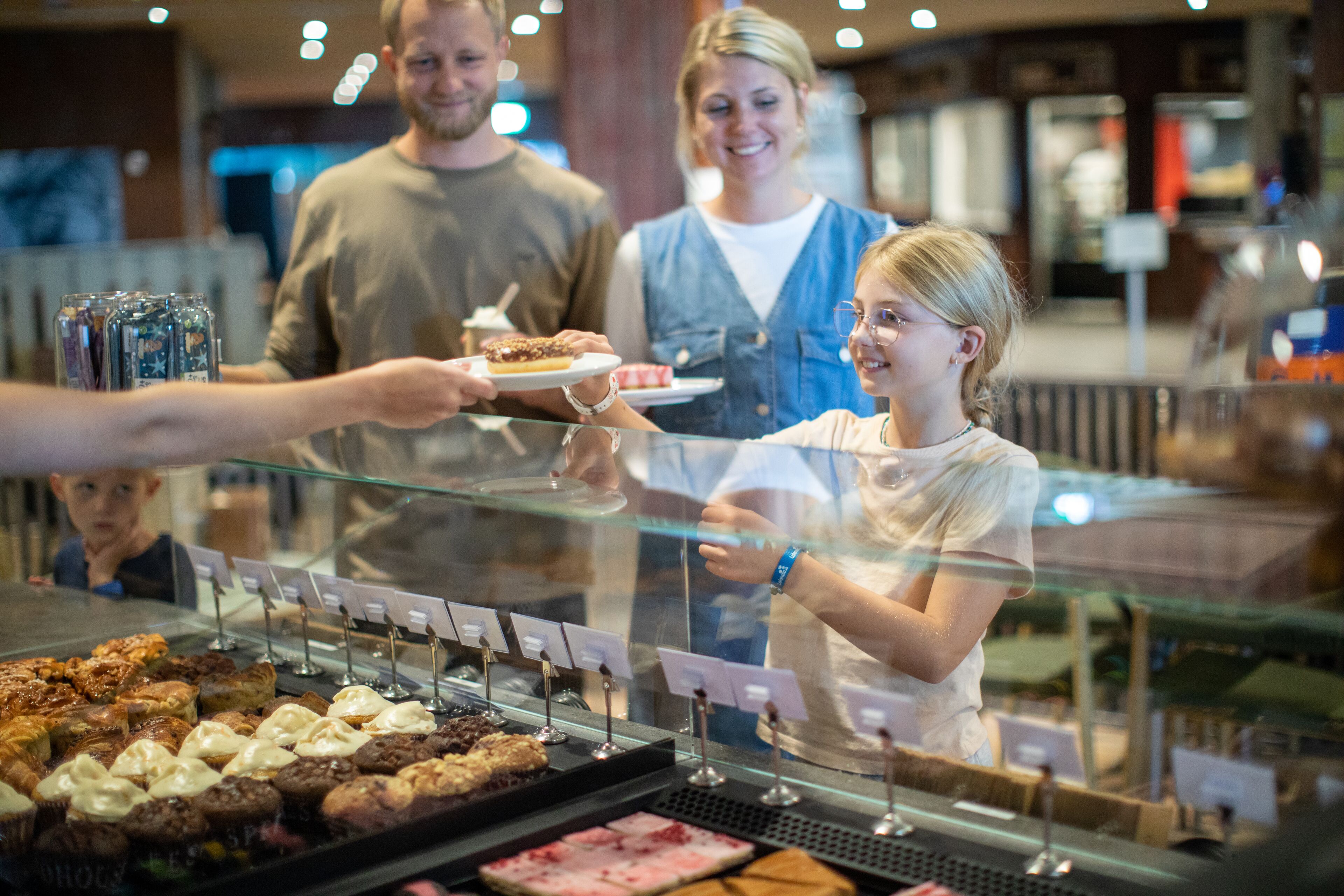 A bakery counter with various baked goods displayed behind a glass case.