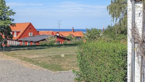 A coastal property with red-roofed buildings, a gravel driveway, and a grassy area. - Stunning apartment in Allinge with WiFi (Allinge)