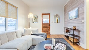 Una sala moderna con sofá, mesa de centro y una puerta de madera.