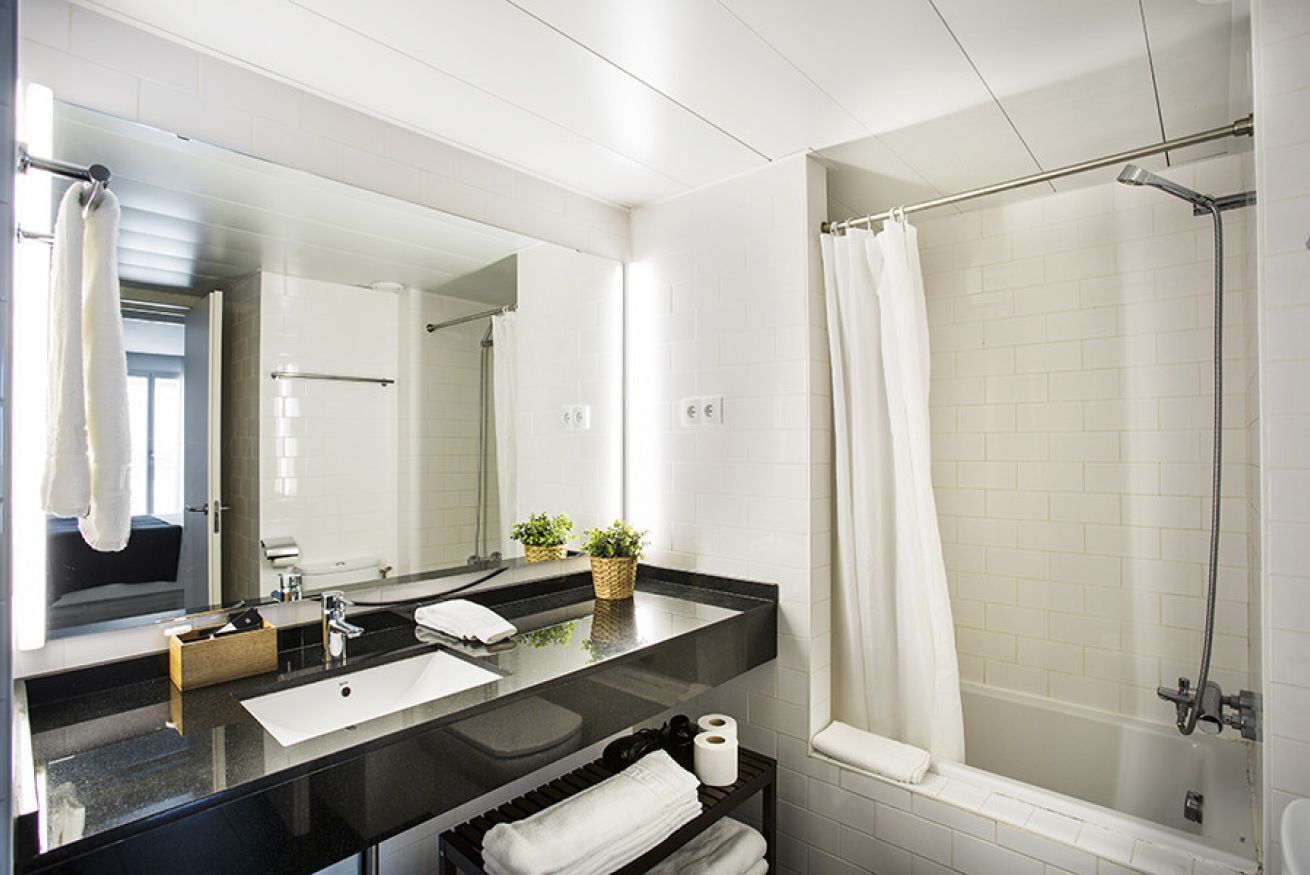 Een bad/douchecombinatie, een haardroger, handdoeken