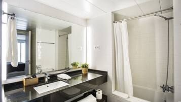 Een bad/douchecombinatie, een haardroger, handdoeken