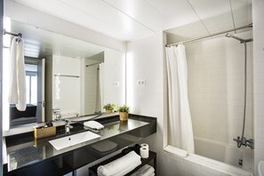 Een bad/douchecombinatie, een haardroger, handdoeken