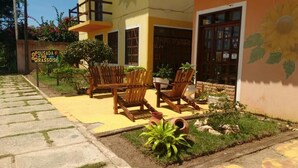 Un edificio con fachada amarilla, muebles de madera en el exterior y un cartel que dice "POUSADA dos GIRAISOS".