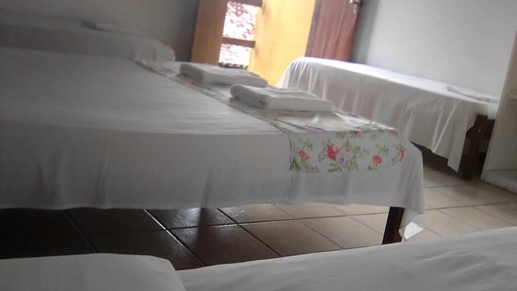 Ein Hotelzimmer mit einem großen Bett, einem kleineren Bett und einer Bank.