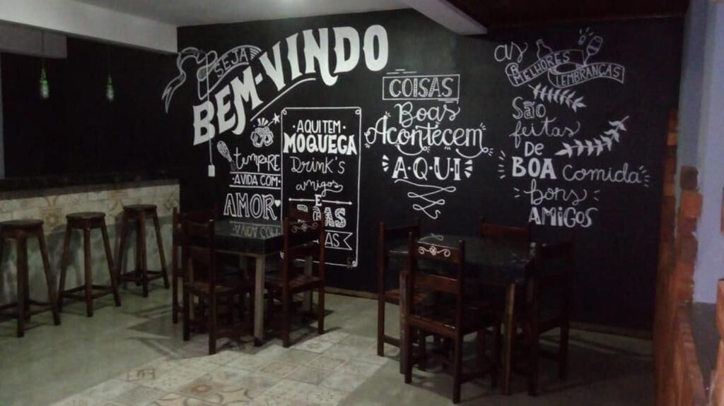 A bar area with a chalkboard displaying various messages and a drink menu.