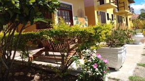 Un edificio con recepción, zona de estar al aire libre y plantas en macetas.