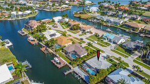 Vista aérea de una zona residencial con casas, muelles y un puerto deportivo.
