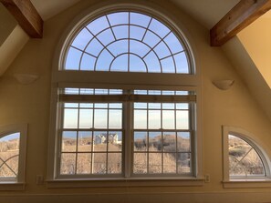Ein Zimmer mit einem großen Bogenfenster im Dach und zwei Fenstern mit Gittermuster.
