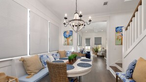 A dining area with a round table, blue and white patterned cushions, and a chandelier. - Gorgeous 4 bed/3.5 bath Home with Private Pool (St. Simons Island)