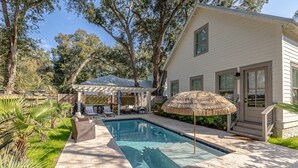 A backyard with a swimming pool, a covered patio, and a house. - Gorgeous 4 bed/3.5 bath Home with Private Pool (St. Simons Island)