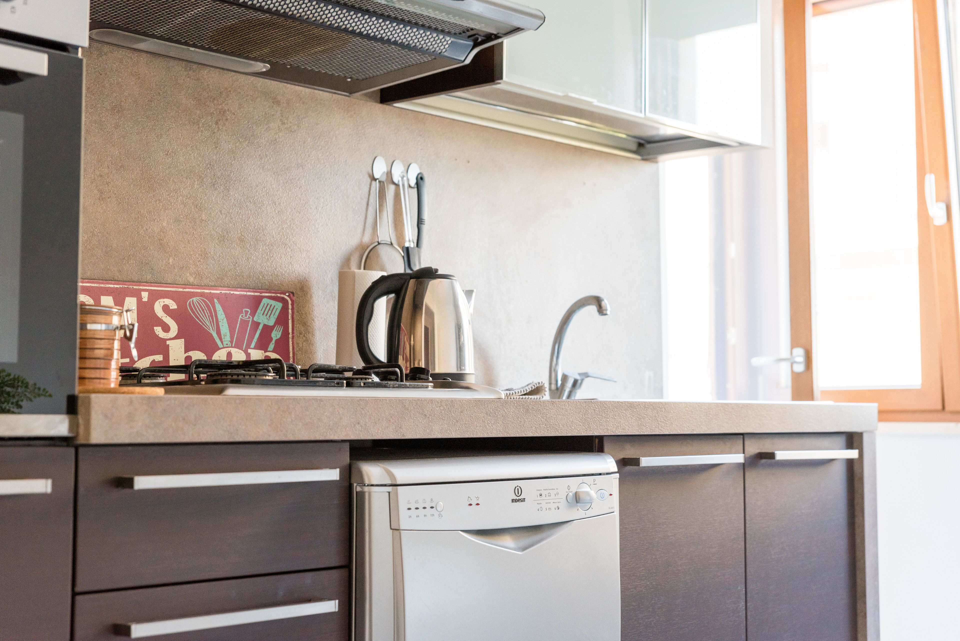 A modern kitchen with a dishwasher, a stove, and a sink.
