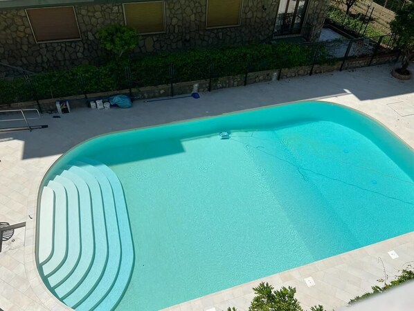 A swimming pool with a curved edge and a small boat in the center.