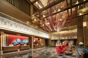 A spacious lobby with a reception desk, seating area, and a large abstract art piece. - Wyndham Fengqing Resort (Lincang)